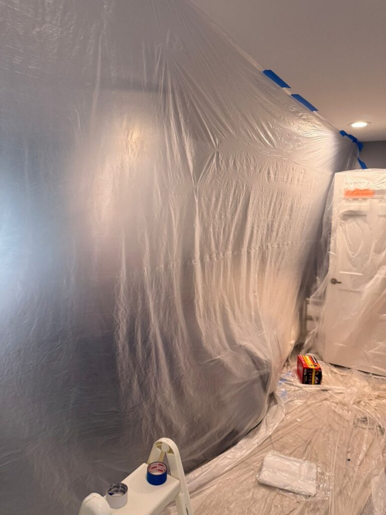 plastic dust barrier along interior wall
