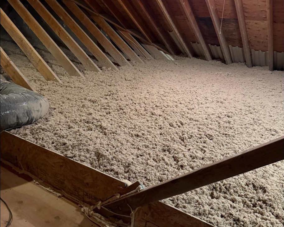 Blown-in cellulose insulation covering an attic floor